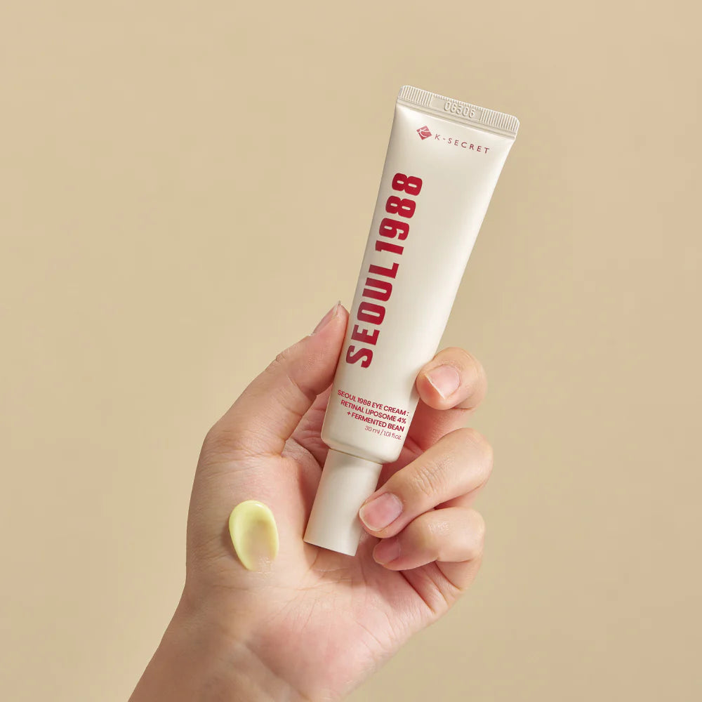 Hand holding tube of KSECRET - SEOUL 1988 Eye Cream : Retinal Liposome + 4 Fermented Bean eye cream.